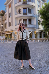 a lady in a jacquard cardigan and a black skirt